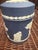 This is a Wedgwood Portland Blue Jasperware cylindrical lidded box featuring classic white neo-classical bas-relief...