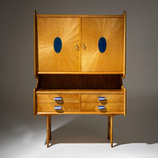 Credenza with a two-door upper section and four drawers, raised on slender legs. The drawer pulls are made of blue-and-...
