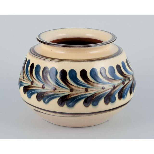 Kähler, Denmark. Ceramic vase. Cow horn technique. Handmade. Glaze in blue and brown tones on a cream coloured base. Circa...