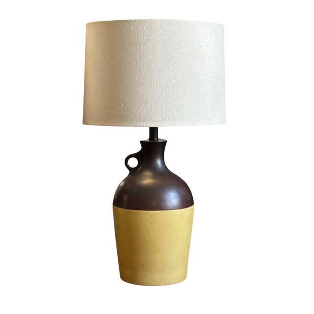 These 1960s plaster/resin composite pottery jugs, with finger loops pair of lamps. Includes shades and round matching...