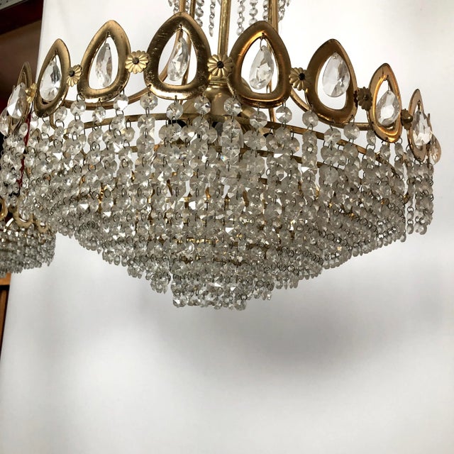 Good vintage conditions for this set of two chandeliers produced in Italy during the 70s. Made from gilded brass and cut...