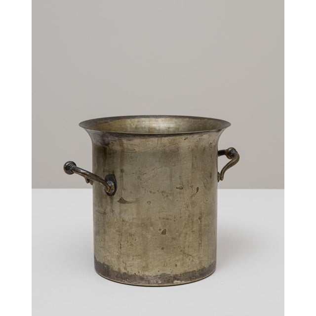 A 20th Century French silver-plated champagne bucket featuring a straightforward cylindrical form softened by a subtly...
