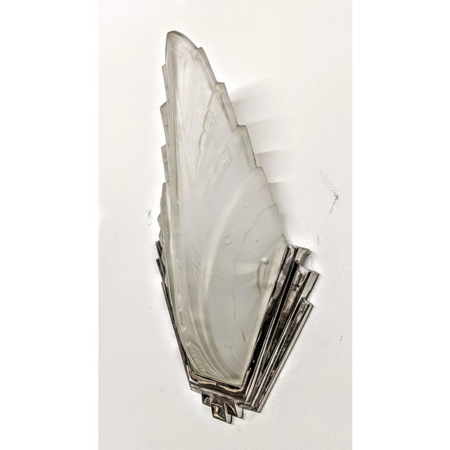 A stunning pair of French Art Deco wall sconces by the French artist “HANOTS“. Each clear frosted molded glass shade are...