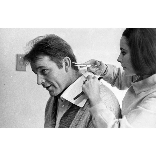 Liz's Scissors 6th March 1964: Elizabeth Taylor gives her future husband Richard Burton (1925-1984) a cursory haircut....