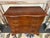 This is a 20th century vintage Eldred Wheeler serpentine chest of drawers. It is cherry wood. It has an ogee bracket base....