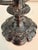 Distinctive vintage two-arm candelabrum crafted of brass with a dramatic black powder-coated finish. Ornate raised grape,...