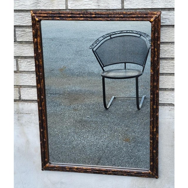 Authentic English antique wall mirror, circa 1920, featuring a finely crafted gilded faux bamboo wood frame with a rich...