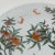 A vintage porcelain plate, hand-decorated with peach trees and fruit, and flying bats. Good condition.
