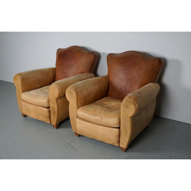 These club armchairs were designed and produced in France in the 1940s. The chairs are made of cognac leather held by...