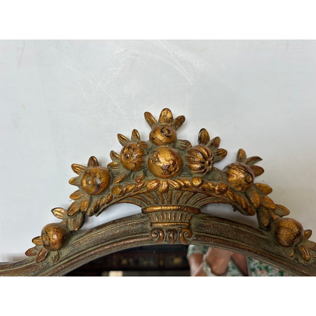 Lovely celadon green and gilded traditional wall mirror from Italy having fruit and foliage decoration.