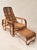 A striking mid-century rattan lounge chair distinguished by its sculptural bent frame, intricate woven surfaces and...