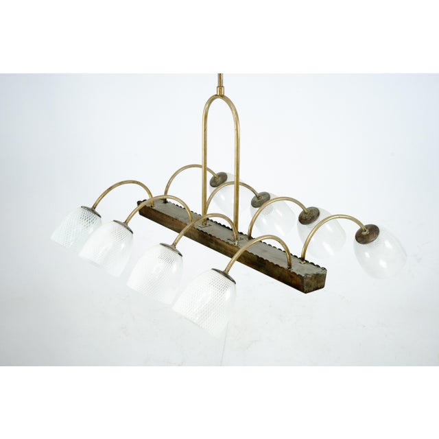 A striking eight-arm chandelier by Venini, featuring hand-blown Murano glass shades in the celebrated reticello technique...