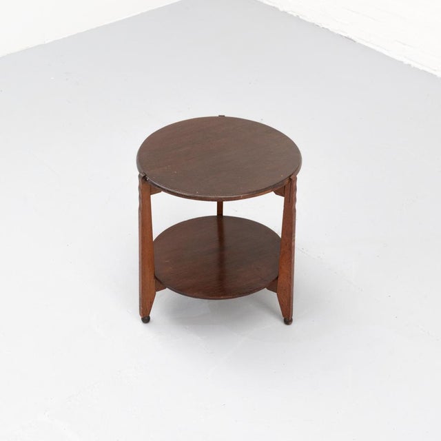 Amsterdamse School side table from the 1920s–1930s, crafted from solid oak. The design features a round top and lower...