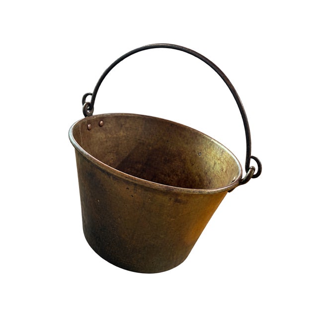 Substantial antique brass hearth cauldron or cooking pot featuring a rounded bottom, riveted brass handle mounts, and a...