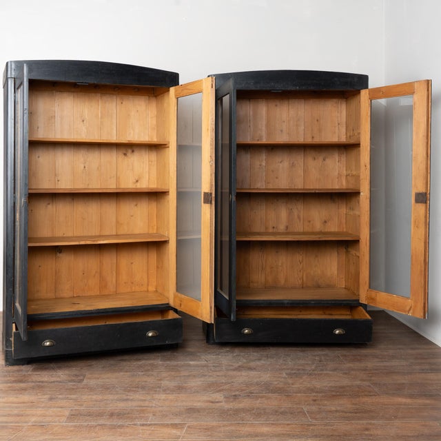 Early 20th-century pair of pine bookcases with a newer matte black painted finish, lightly distressed to reveal natural...