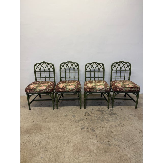 Original set of four McGuire green stained bamboo dining chairs with leather wrapping and floral fabric seat cushions. Use...