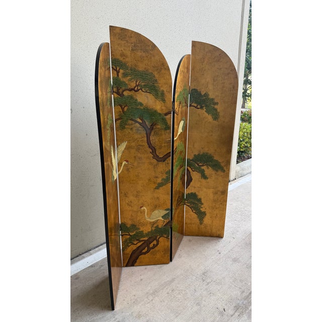 A striking vintage Chinese four-panel folding screen featuring a classic hand-painted scene of cranes among pine trees,...