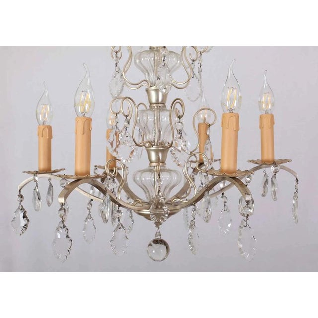 The chandelier is made of white metal and decorated with cut and polished glass. Restored electrical installation: new...