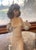 Lladro female figurine with curly brown hair, wearing a floral headband and holding flowers. She is wearing a slinky white...