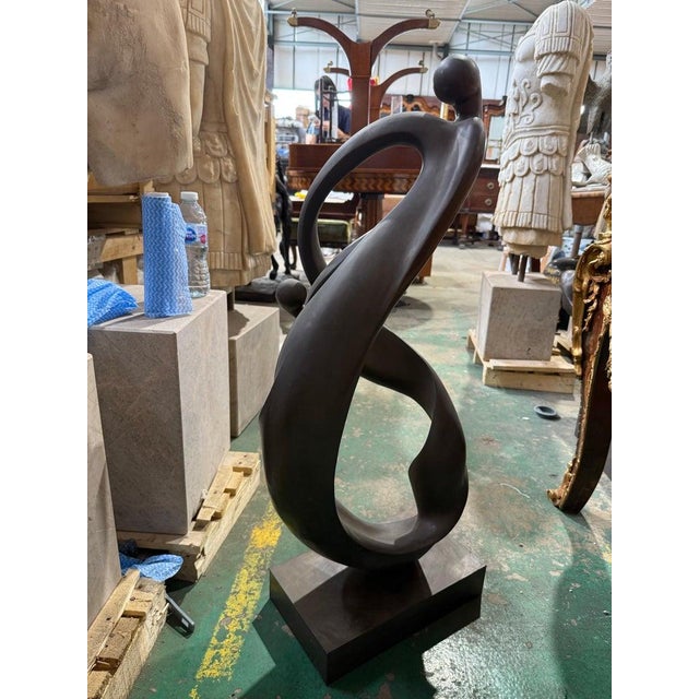An elegant and fluid contemporary abstract bronze sculpture, suggestively titled Unity in Motion, representing three...
