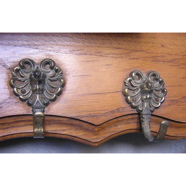 An Antique 19th Century carved wood Shelf. The Shelf has 5 brass hooks decorated with cherub angels. The shelf itself has...
