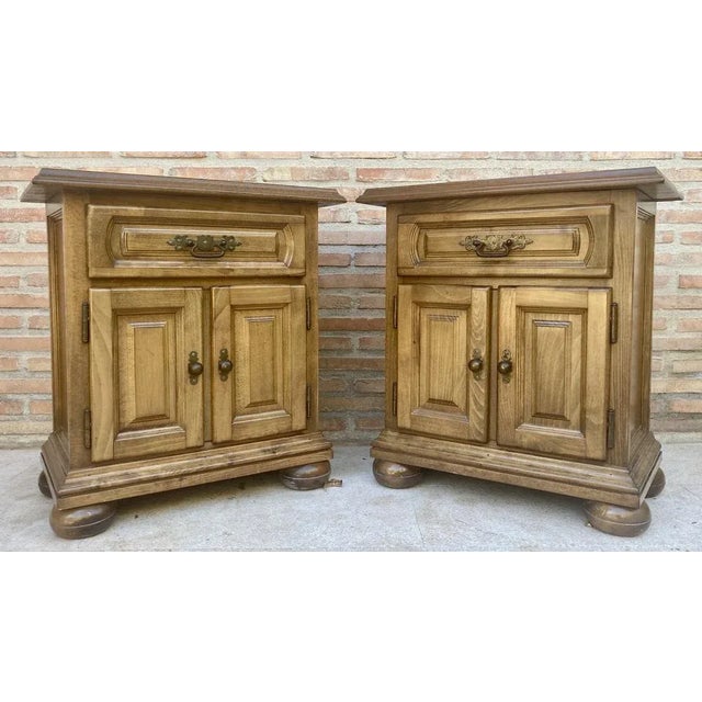 Fabulous pair of Castilian nightstands from the 1960's. It has a drawer at the top and a door at the bottom, resting on...