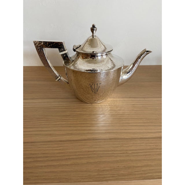 A beautifully crafted Arts & Crafts hand‑hammered sterling silver tea set by Whiting, c.1890–1910, comprising a teapot,...