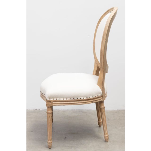 Oval back Louis XVI side chair in distressed and dry brushed light finish. Neutral upholstrey with tack trim and...