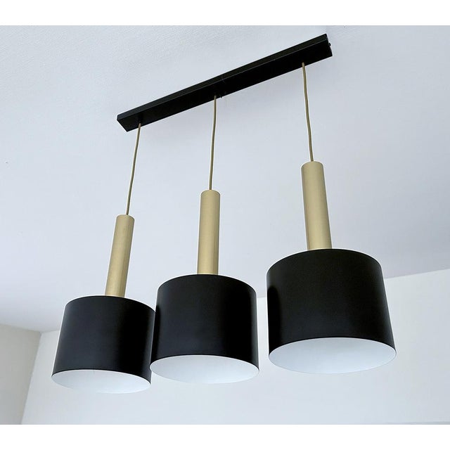 Very large Vintage Pendant lights featuring 3 black enameled shades with a large gold anodized finials , originally the...