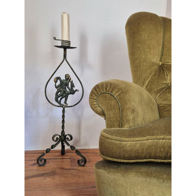 A floor candelabra in wrought iron with antique bronze finish, Swedish Grace 1920/30s. Decor in cast iron of huntress...