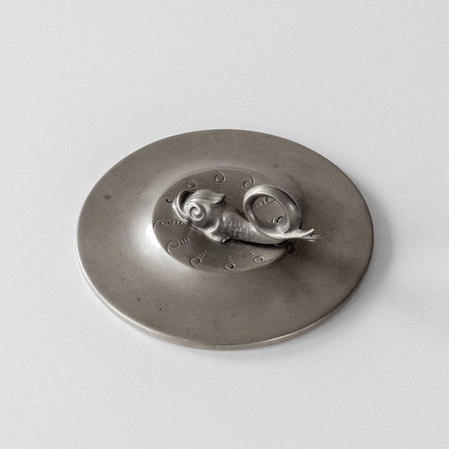 This pewter hand mirror exemplifies the Swedish Grace movement, Sweden's distinctive interpretation of Art Deco that...