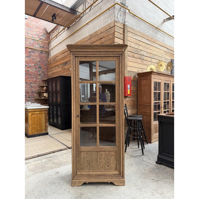 This antique display cabinet made of unfinished solid oak has been fully restored. It features a large glass door that...