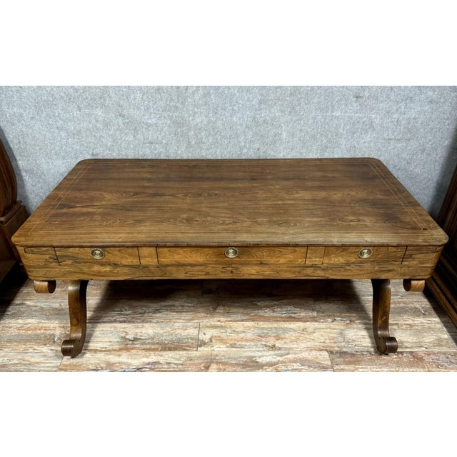 Charles x period center desk in rosewood and lemonwood, circa 1820 three drawers in the frieze x-shaped legs joined by a...