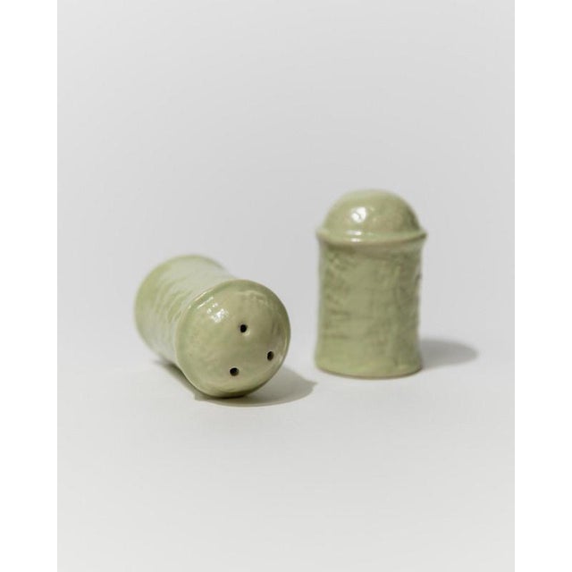 Minimalist ceramic salt and pepper shakers in a soft mint tone, crafted in italy in the 1970s. Their sculptural form and...