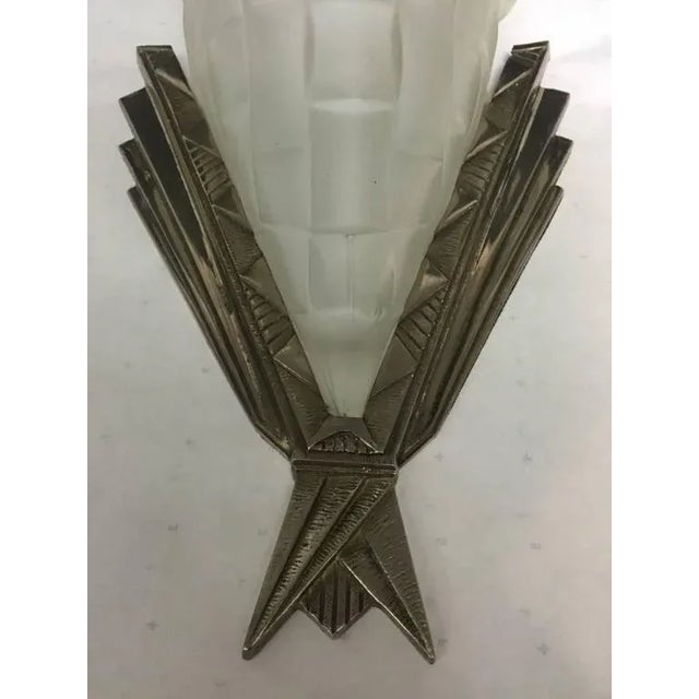 A pair of French Art Deco wall sconces by the French artist Degue. With molded clear frosted glass decorated with floral...