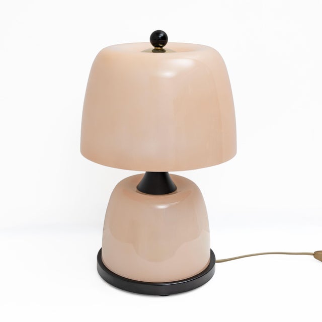 Pair of refined table lamps crafted in Murano glass in a delicate blush pink tone, featuring a smooth, luminous surface...