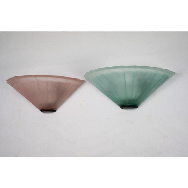 Elegant pair of wall sconces produced by de majo in the 1980s. Each piece features a fan-shaped design in textured pink or...