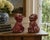 A wonderfully weathered pair of antique cast stone foo dogs, retaining their original red painted finish with beautifully...