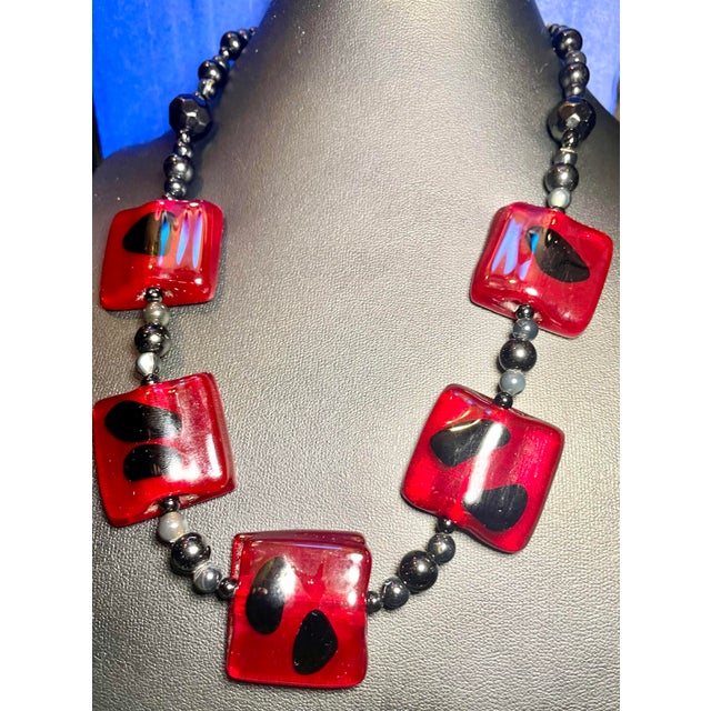 The dramatic color contrast between the ruby red glass squares and rounded black onyx, faceted black glass and agate...