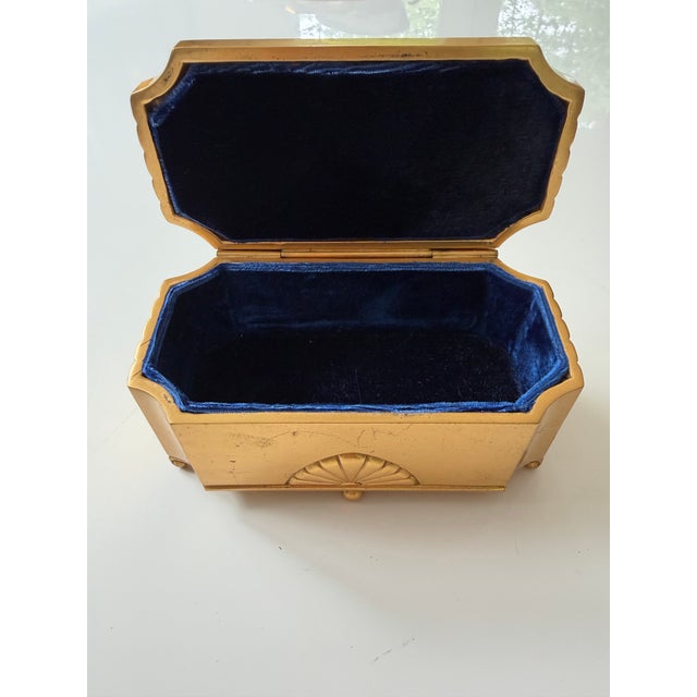 Elegant American Art Deco jewelry casket by Jennings Brothers, featuring a sculptural sunburst/fan motif and rich gilt...