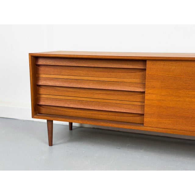 Perfectly proportioned, low teak sideboard with three drawers and a sliding door with a round recessed handle. Includes...