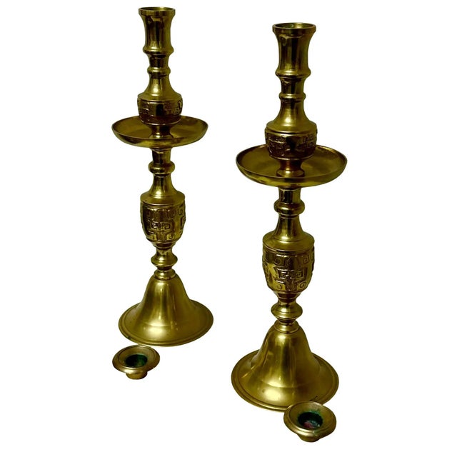 A striking pair of 1950's brass Hollywood Regency candlesticks are by James Mont in the asian taste. There's a bow sash on...