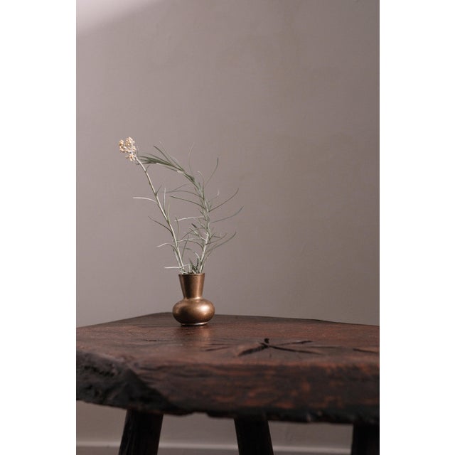 Solid wood coffee table. The edge partially follows the natural shape of the trunk, while four legs support the whole. A...