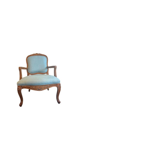 Beautiful vintage accent chair featuring carved solid wood frame and fresh sky-blue upholstery. The piece has graceful...