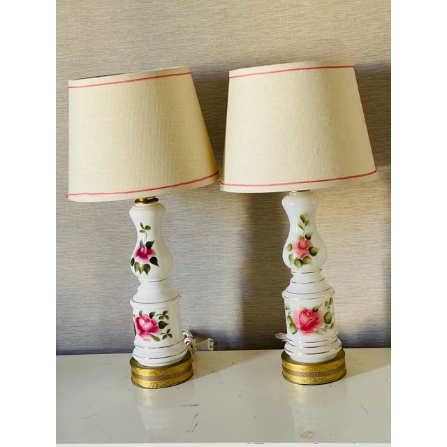 Antique Victorian labels pair of milk glass lamps with Handpainted red roses , on reticulated brass bases. .