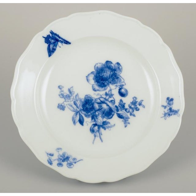 Meissen, Germany. Four dinner plates in porcelain. Hand-painted with floral motifs and insects in blue. Approximately...