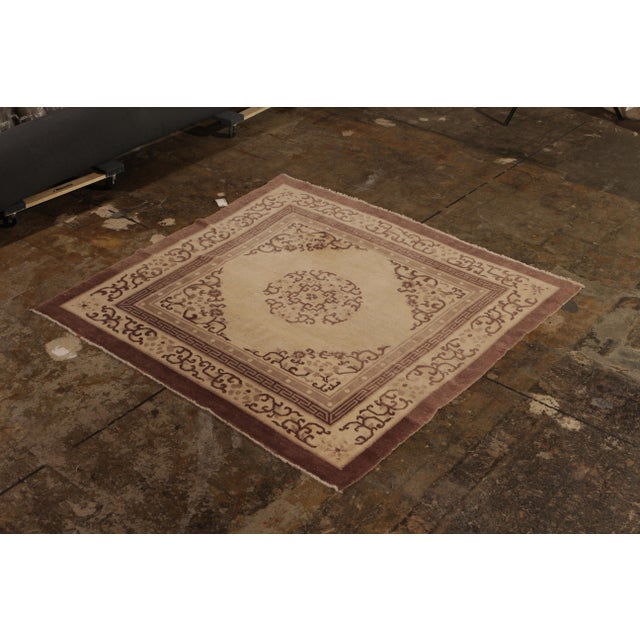 Hand knotted in wool originating from China circa 1920, this antique rug connotes a Peking Art Deco design in a rich...