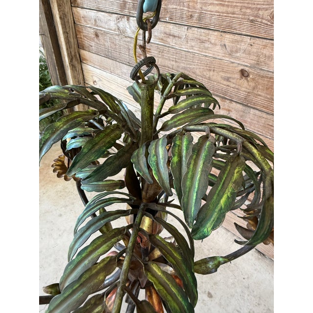 A vibrant and sculptural example of Italian tole lighting, this Mid-20th Century palm chandelier channels tropical regency...