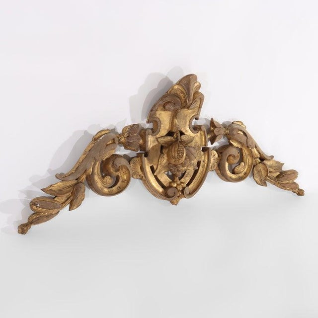 An antique French Renaissance Revival mirror crest, meticulously carved from wood and adorned with a rich gilt finish,...