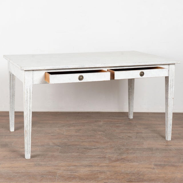 19th century Swedish table or writing desk crafted with two drawers fitted with brass pulls. The table stands on tapered...